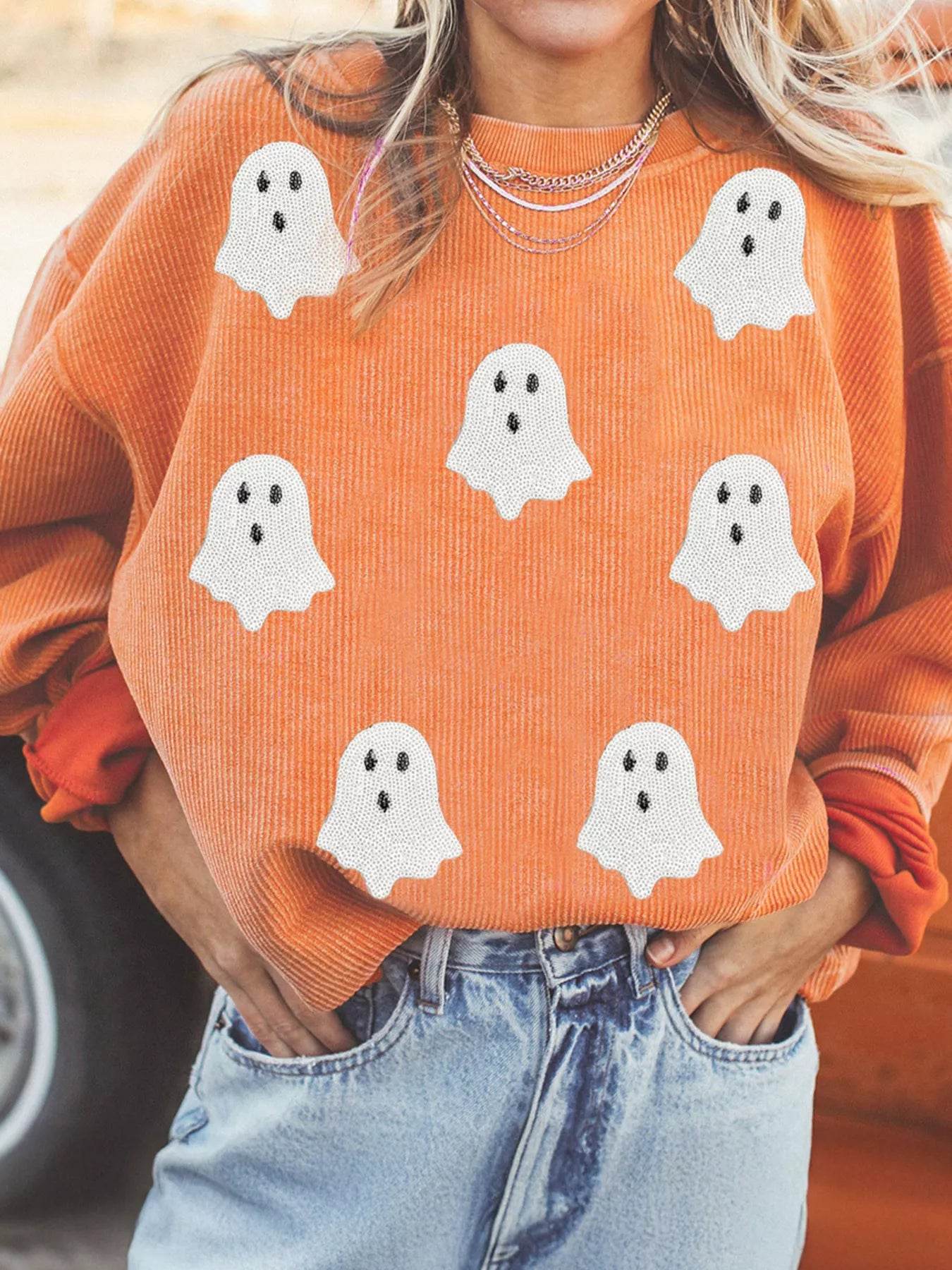 Sweatshirt fantôme Halloween femme en orange avec motifs de fantômes blancs sur un fond texturé